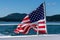 Symbol of freedom, American flag flying on the back of a boat cruising in the Salish Sea of the San Juan Islands, tree covered isl