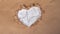 A symbol of the harm of salt to the heart, a cardiogram on white salt in a paper brown heart