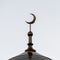 The symbol of Islam is a golden crescent moon in the evening or morning sky. Silhouette of the top of the mosque minaret. A square