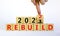 Symbol of planning 2022 rebuild new year. Businessman turns a wooden cube and changes words `rebuild 2021` to `rebuild 2022`.