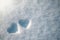 The symbol of two hearts drawn on the snow, on a sunny winter day. Romance. Valentine's Day. Copy space.