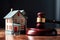 A symbolic representation of real estate law with a wooden gavel and a small house model