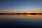 Symmetrcal, beautiful view of Trasimeno lake Umbria, Italy at sunset, with orange and blue tones in the sky