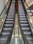 Symmetric escalator to darkness inside shopping mall