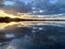 Symmetric view of the fluffy clouds reflecting on the lake water at sunset in Los Nietos