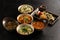 Symmetrical composition of an-Asian and Pan-Asian cuisine on a stylish black concrete kitchen table. Dumplings, soups, side dishes