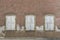 Symmetrical facade of abandoned, dilapidated house with 3 windows with shutters