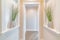 Symmetrical hallway with white cased opening and plants