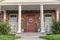 Symmetrical house facade with covered porch near sunset