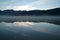 Symmetrical mountains reflected in the lake with beautiful blue skies and dense mist