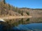 Symmetrical mountains reflected in the lake with a beautiful blue sky and fluffy clouds