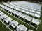 Symmetrical Pattern Of White Folding Chairs At Outdoor Garden Event