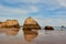 Symmetrical reflection of the limestone rocks in the water of low tide. Praia dos Tres Castelos, Portimao