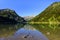 Symmetrical reflections of mountain range and boat in the clear water of Lake Vilsalpsee, Tyrol, Austria