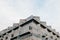 A symmetrical snapshot of a building corner with lots of windows against the sky