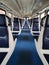 a symmetrical Vertical photo inside of empty seated carriag in clean modern train