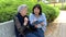 Sympathetic carer teaching the grey-haired elderly woman how to use a tablet in social networks