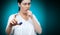 Symptoms of asthma. Portrait of a young coughing woman showing an inhaler. The background is blurred. Hand in focus. Copy space