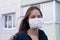 Symptoms of a coronavirus. Young woman in antiviral mask holding her throat, coughing