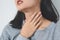 Symptoms from flu season in winter concepts. Close up woman touching her neck and suffering from sore throat