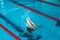 Synchronized swimming athlete trains alone in the swimming pool. Training in the water upside down. Legs peek out of the water.