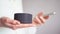 Synchronizing phone and a portable voice assistant speaker to control a smart home. Close-up of girl`s hands hold for