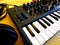 Synthesizer on yellow background with orange patch cables and headphones