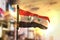 Syria Flag Against City Blurred Background At Sunrise Backlight