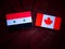 Syrian flag with Canadian flag on a tree stump isolated