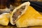 Syrian-Lebanese pie stuffed with meat called sfiha with one open in a cutting board in black background close