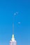 Syringe filled with transparent liquid with droplet blue background close up