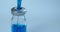 Syringe filling blue vaccine, medicine from vial. Close-up video of pharmaceutical product for vaccination, copy space