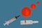 A syringe and a glass ampoule with the inscription CORONAVIRUS COVID-19 VACCINE on the background of an impromptu image of the