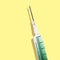 Syringe with a green solution on a yellow background