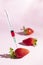 Syringe injecting artificial coloring into a fresh strawberry.