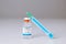 Syringe leaning on a vaccine bottle with COVID-19 sign on white  background. Global pandemic and healthcare concept.