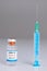 Syringe leaning on a vaccine bottle with COVID-19 sign on white  background. Global pandemic and healthcare concept.