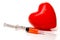 Syringe beside model heart