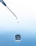 The syringe needle on the blue water background with splash and drops