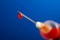 syringe needle with droplet of blood red on blue