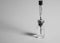Syringe needle pierces the cap of medical vial with transparent liquid. Black and white photo.