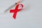 Syringe and red ribbon on light wooden background. World AIDS Day