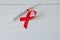 Syringe and red ribbon on light wooden background. World AIDS Day