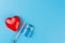 A syringe with a vaccine on blue background, a lock symbol of safety and security, immunization week, model heart, protection from