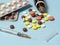 syringe and various medications, vitamins pills laid out on a background