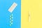 Syringe and various tablets and capsules isolated on yellow and blue background.concept of medicine.Medicines for the treatment of