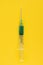 Syringe on a yellow background. Medication and Health Care Concept.