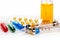 Syringes with medication, blister pack, vials and bottle with colored fluid on white background