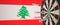 Syringes with a vaccine hit target near the Lebanese flag. Successful medical research and vaccination in Lebanon
