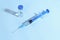 Syringes and vaccines are placed on the table in the medical office, cool toned image, blue color temperature